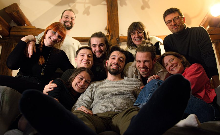 La troupe serrée les uns contre les autres dans un canapé, tout sourire