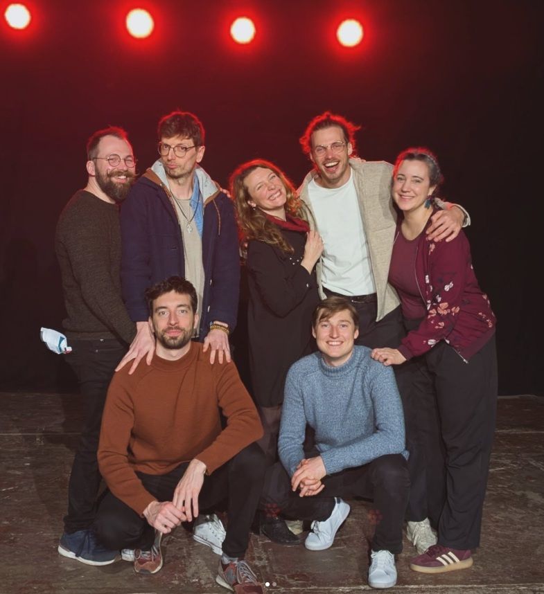La Confrérire sur scène à Liège sous les projecteurs rouges à la fin d'un spectacle d'impro